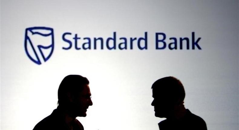 Businessmen chat in front of a Standard Bank logo in Sandton outside Johannesburg in a file photo.Sibeko