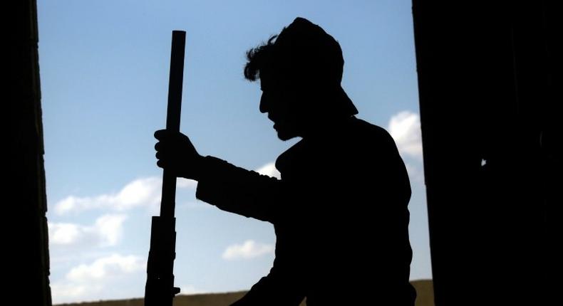 A member of the Syrian Democratic Forces holds a weapon in the Al-Senaa neighbourhood of Raqa on June 21, 2017