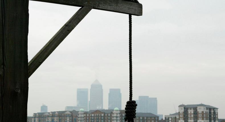 A hangman's noose outside The Prospect of Whitby pub with Canary Wharf in the background.