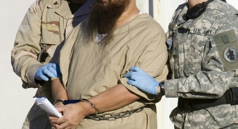 A detainee is escorted by military guards at the US prison at Guantanamo Bay, Cuba, in a 2006 photo