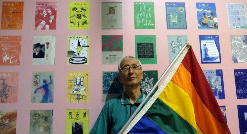 This picture taken on May 19, 2017 shows Taiwanese gay rights campaigner Chi Chia-wei, 59, posing for a photograph with a flag during an exhibition in Taipei