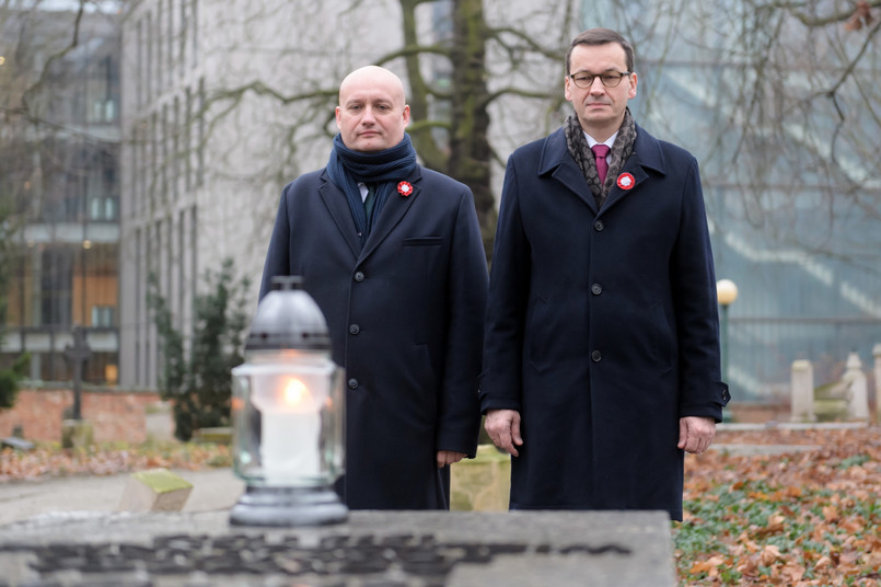 Premier RP Mateusz Morawiecki i wojewoda wielkopolski Zbigniew Hoffmann składają kwiaty na mogile generała Stanisława Taczaka na Cmentarzu Zasłużonych Wielkopolan.