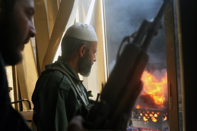 Bojownicy obserwują płonące budynki