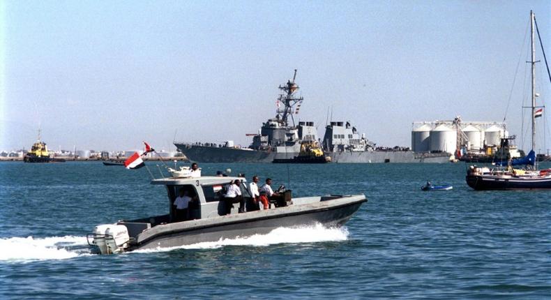 Yemeni marine police patrol around the damaged destroyer USS Cole as it is towed out of Aden harbor on October 29, 2000 -- US President Donald Trump has confirmed that a key plotter of the attack was killed in a US air strike