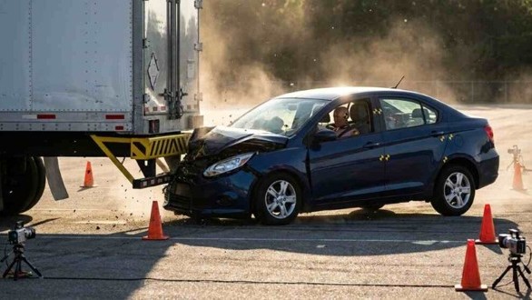 Osobné auto pri náraze do zadnej časti kamióna testuje účinnosť ochrannej zábrany proti zasunutiu pod náves. 