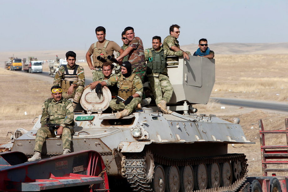 Peshmerga forces ride on military vehicles on the east of Mosul during preparation to attack Mosul, Iraq