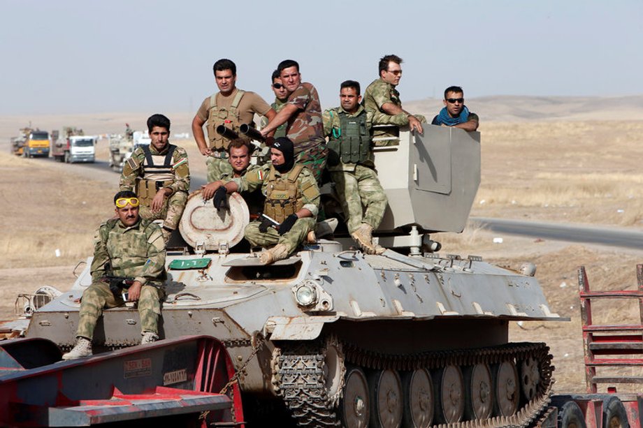 Peshmerga forces ride on military vehicles on the east of Mosul during preparation to attack Mosul, Iraq