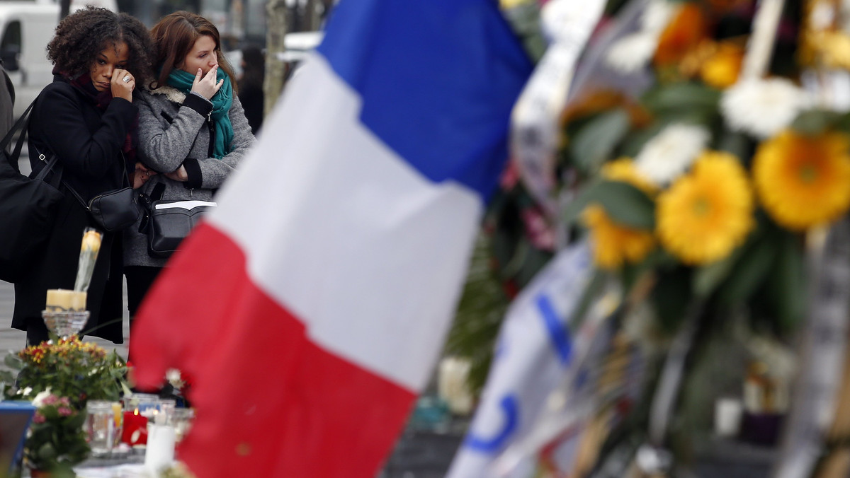 Two women cry as they pay tribute to the victims of Paris attacks at the Place de la Republique in Paris