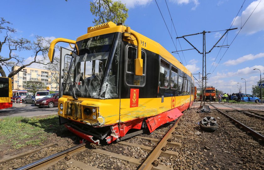 Samochód zaklinowany pomiędzy tramwajem a słupem. W środku ciężarna kobieta i dziecko