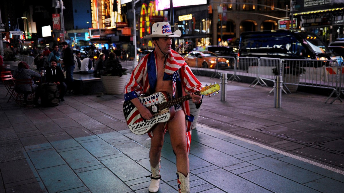 A Naked Cowboy performer supporting Donald Trump walks through Times Square in New York