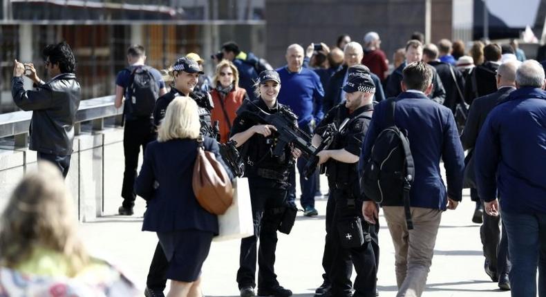 Armed woman police officers patrol with their male colleagues on London Bridge in London