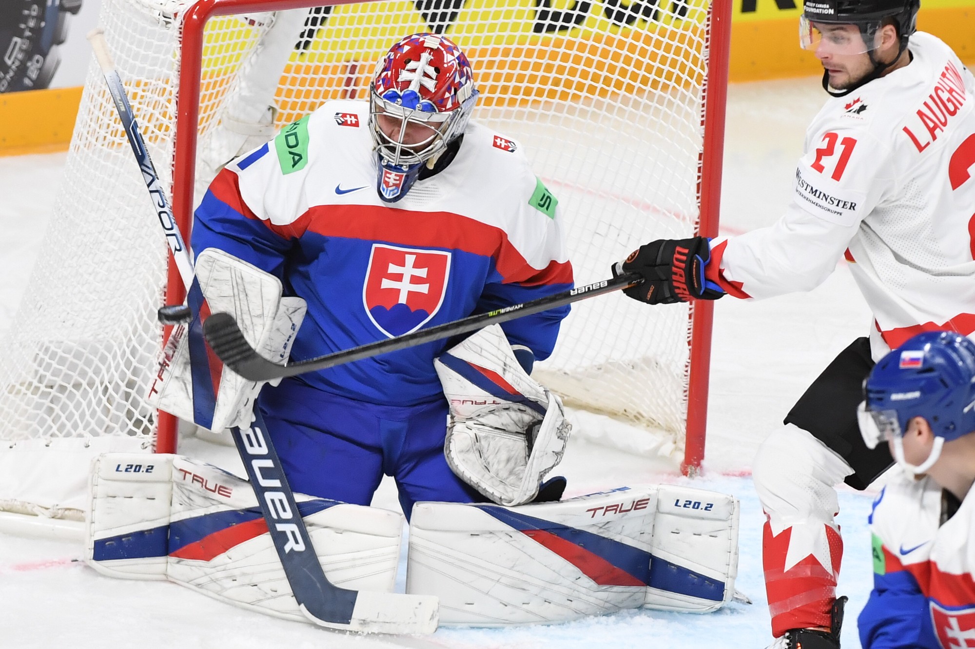Brankár Slovenska Samuel Hlavaj, vpravo center Kanady Scott Laughton.