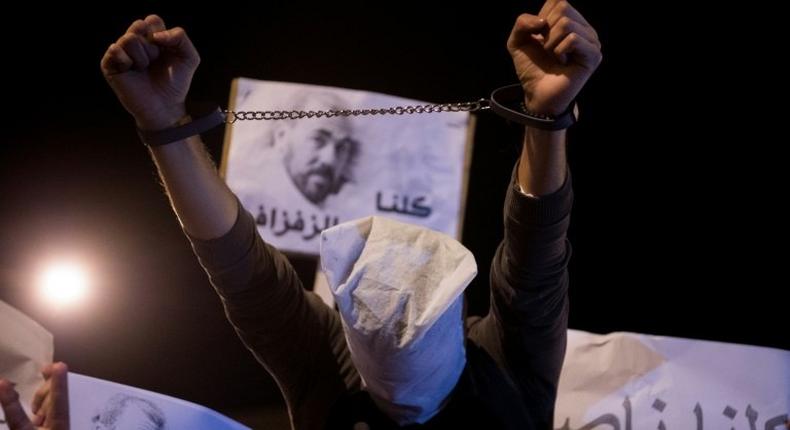 Demonstrators in Morocco's neglected northern Rif region hold pictures of arrested protest leader Nasser Zafzafi during a night-time rally in the city of Al-Hoceima on May 30, 2017