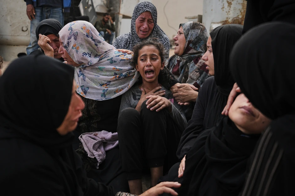 Lijan Al-Za'anin teše rođaci dok oplakuje gubitak svog oca, koji je poginuo na putu ka centru za distribuciju pomoći, u mrtvačnici bolnice Al Šifa u gradu Gazi