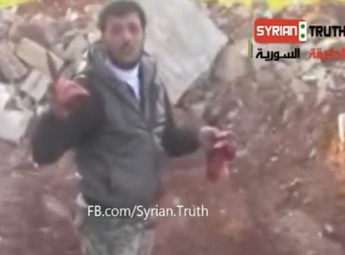 Syryjski bojownik z wyciętym sercem wroga