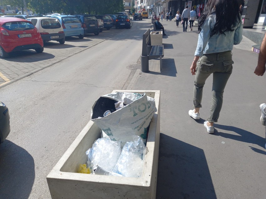 Između klupa žardinjere pune smeća