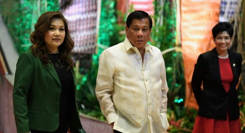 Philippine President Rodrigo Duterte (C) and his partner Honeylet Avancena (L) arrive to meet leaders upon their arrival for the opening ceremony of the Association of Southeast Asian Nations (ASEAN) leaders' summit in Manila