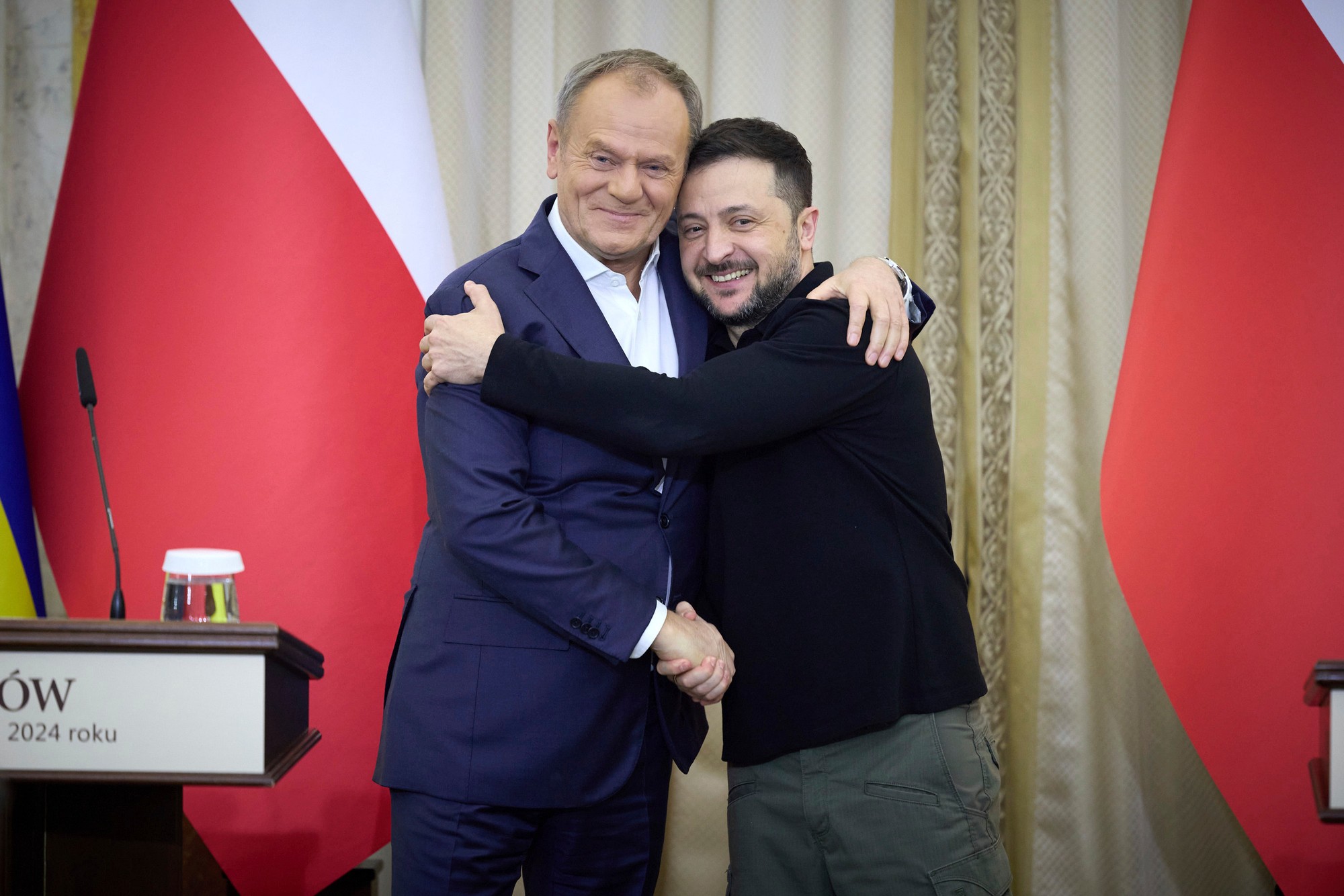 Ukrajinský prezident Volodymyr Zelenskyj (vpravo) a poľský premiér Donald Tusk si podávajú ruky počas stretnutia v západoukrajinskom meste Ľvov.