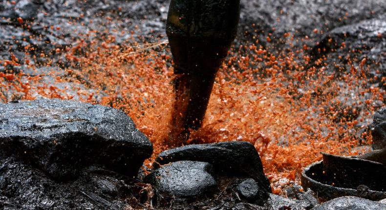 Crude oil sprays from a well bucket as a result of mining processes on December 22, 2008 in Bojonegoro, Indonesia.