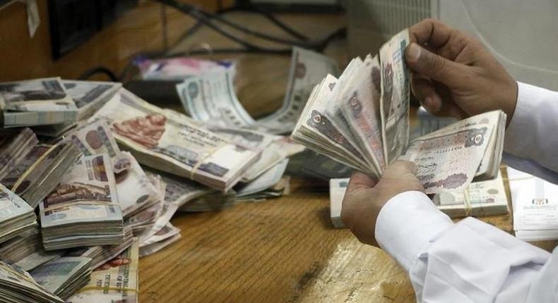 An employee counts money at a bank in Cairo September 4, 2014.  REUTERS/Asmaa Waguih
