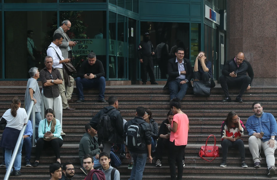 Ljudi čekaju ispred zgrade dok traje akcija policije