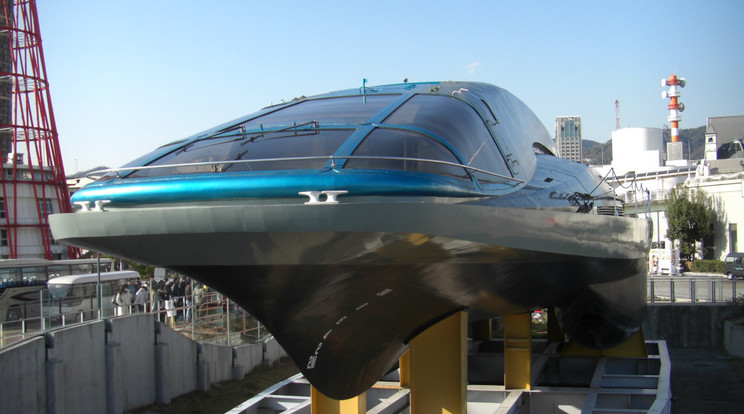 A Yamato-1 a kobei tengerészeti múzeumben. Ennek a 30 méteres japán hajónak 1992-ben MHD meghajtással sikerült elérnie a 6,6 csomós (mintegy 12 km/h) sebességet, miközben a hatékonysága nagyjából 30 százalékos volt. Ma már sokkal fejlettebb technológia áll rendelkezésre a nagyobb tömeg mozgatására és nagyobb sebesség elérésére. / Fotó: Mugu Shisai/Wikimedia Commons