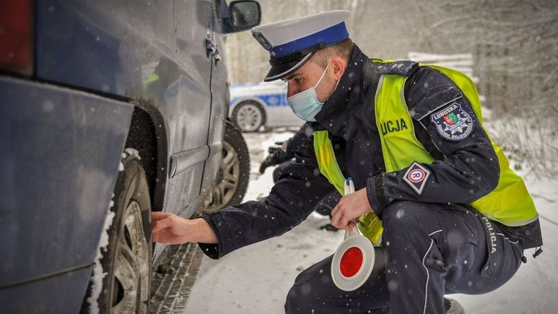 Policjant sprawdza stan techniczny samochodu