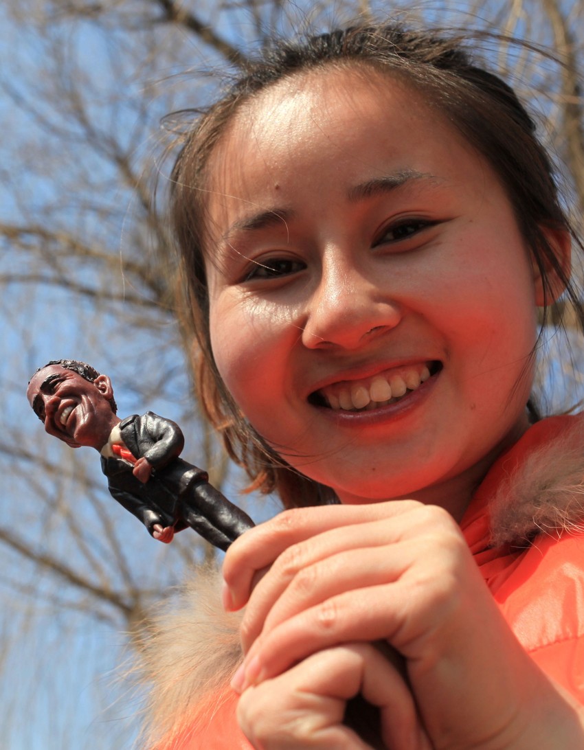 Kineskinja drži figuricu Baraka Obame