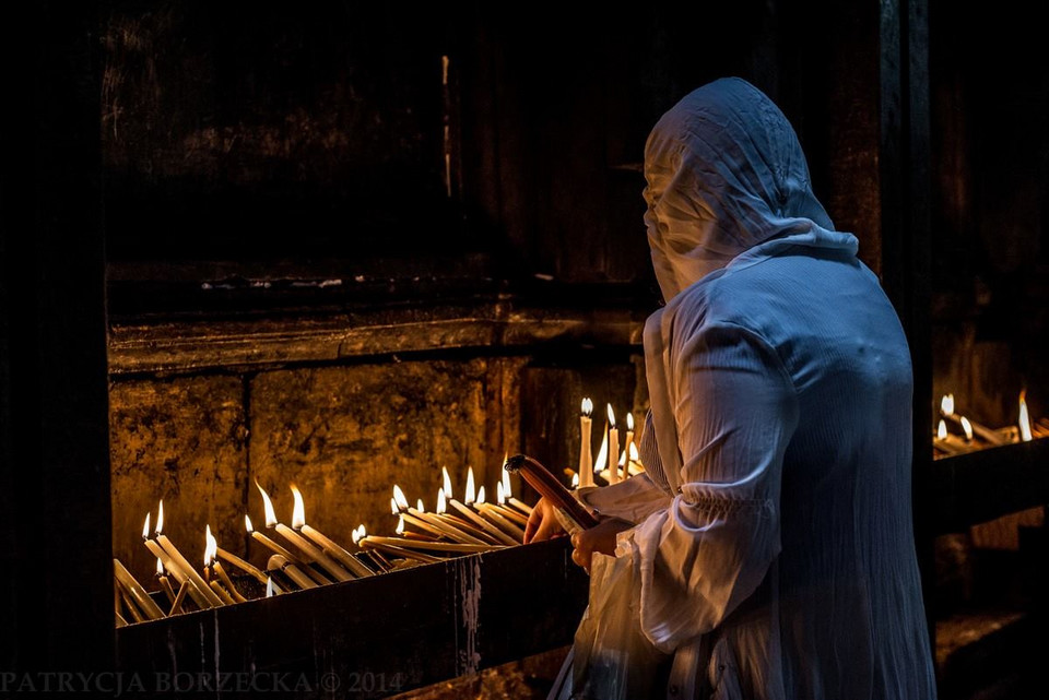 Chrześcijanka zapala świece w Bazylice Grobu Świętego składając je w ofierze Jezusowi Chrystusowi. Jerozolima, Izrael, 2014