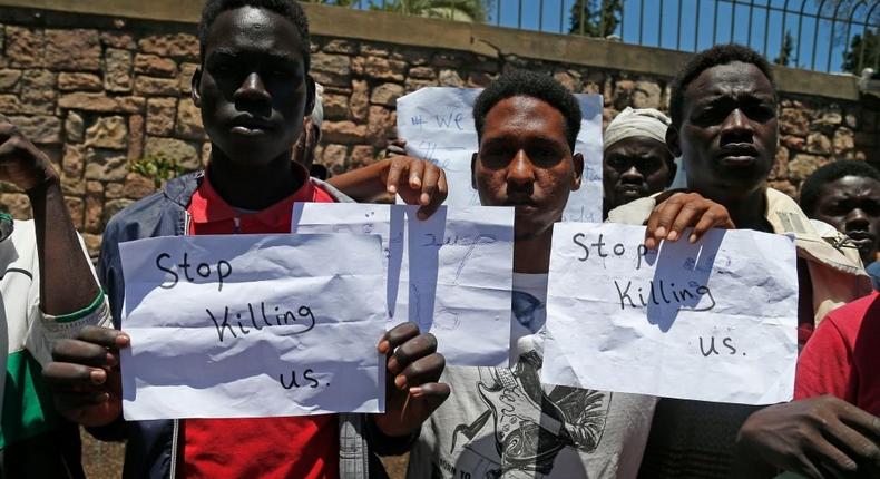 Migrants hold placards during an anti-racism demonstration in the Moroccan capital Rabat on June 28, 2022. (Photo by -/AFP via Getty Images)