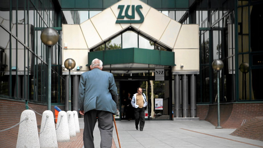 Starszy mężczyzna idący w stronę budynku ZUS (zdjęcie ilustracyjne) 