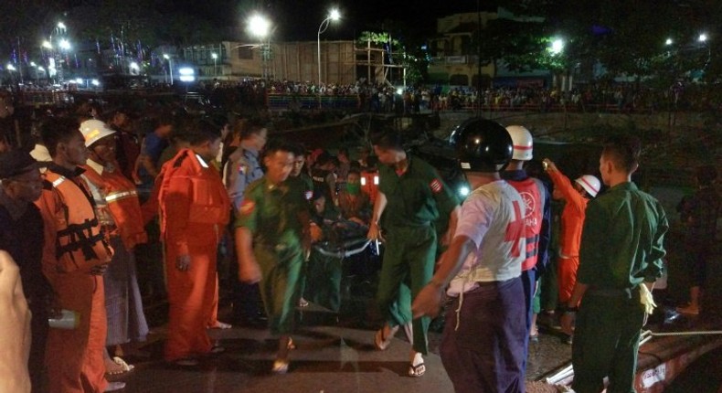 Myanmar soldiers and members of a rescue team carry the body of a passenger after a ferry sank in the Nga Wun River in Pathein with at least 20 dead