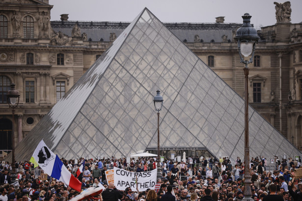 epaselect epa09350329 Thousands of protesters gather by the Louvre pyramid during a demonstration against the COVID-19 vaccination in Paris, France, 17 July 2021. In a recent TV statement, French President Emmanuel Macron announced France will extend the use of its Vaccinal Passeport to cultural place, transport, restaurant, etc, after Covid-19 infections soared this week because of the more infectious Delta variant. EPA/YOAN VALAT Dostawca: PAP/EPA.