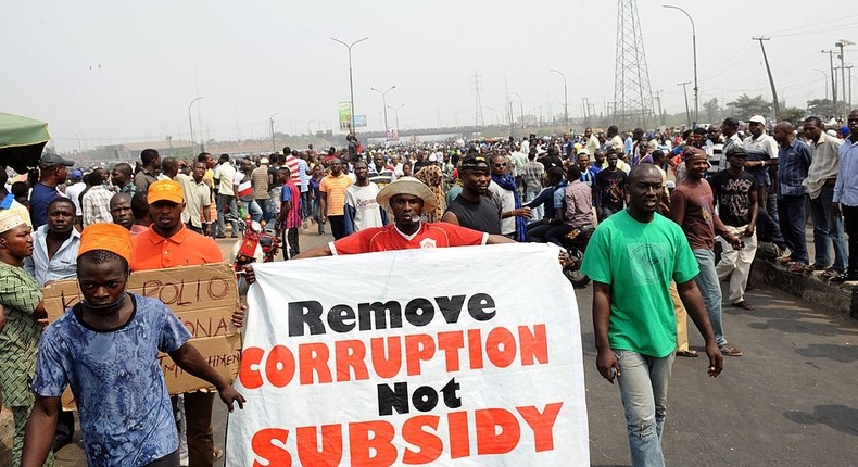 People hold a banner as they protest against hiked in pump price by the government during a worker's rally at Gani Fawehinmi Partk, Ojota district in Lagos on January 13, 2012. The government and Labour are scheduled to meet again tomorrow to resolve the stalement at yesterday's meeting in order to put an end to on-going strike following government scrapping of fuel subsidy. AFP PHOTO/ PIUS UTOMI EKPEI (Photo credit should read PIUS UTOMI EKPEI/AFP via Getty Images)