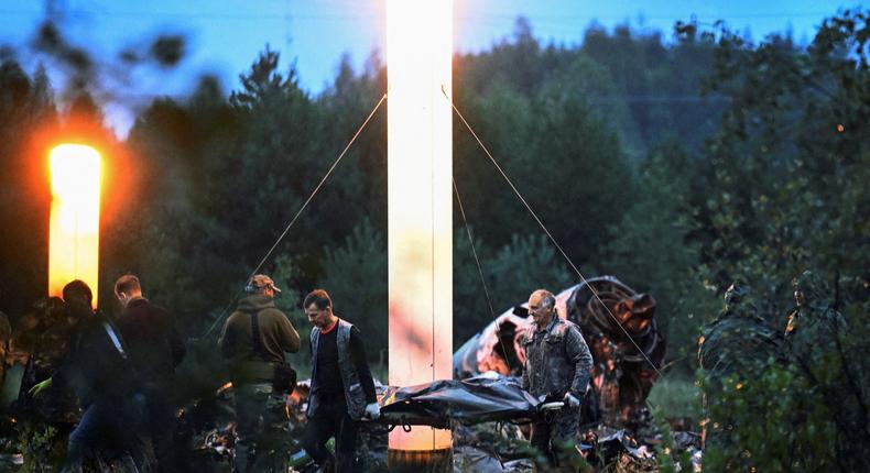 Emergency specialists carry a body bag near wreckages of the private jet linked to Wagner mercenary chief Yevgeny Prigozhin at the crash site in the Tver region, Russia, August 24, 2023.Reuters