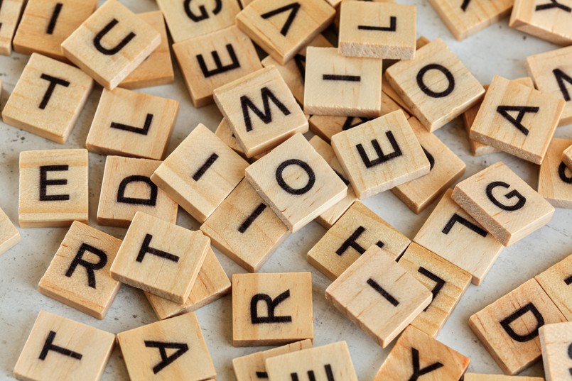 Litera Litery Pile,Of,Wooden,Tiles,With,Various,Letters,Scattered,On,White