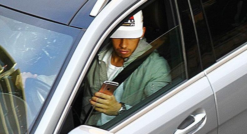 Lewis Hamilton driving and playing with his phone