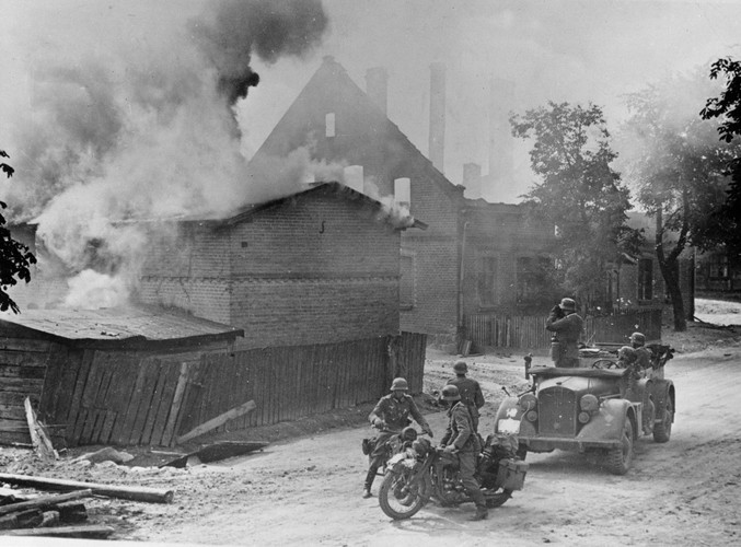 Wrzesień 1939, niemieccy żołnierze obserwują płonące budynki podczas inwazji na Polskę