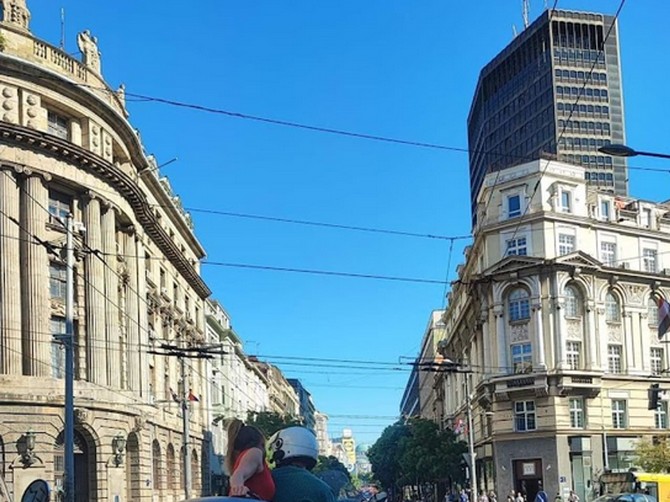 Devojka u haljini i štiklama u nezgodnoj pozi se na motoru vozi