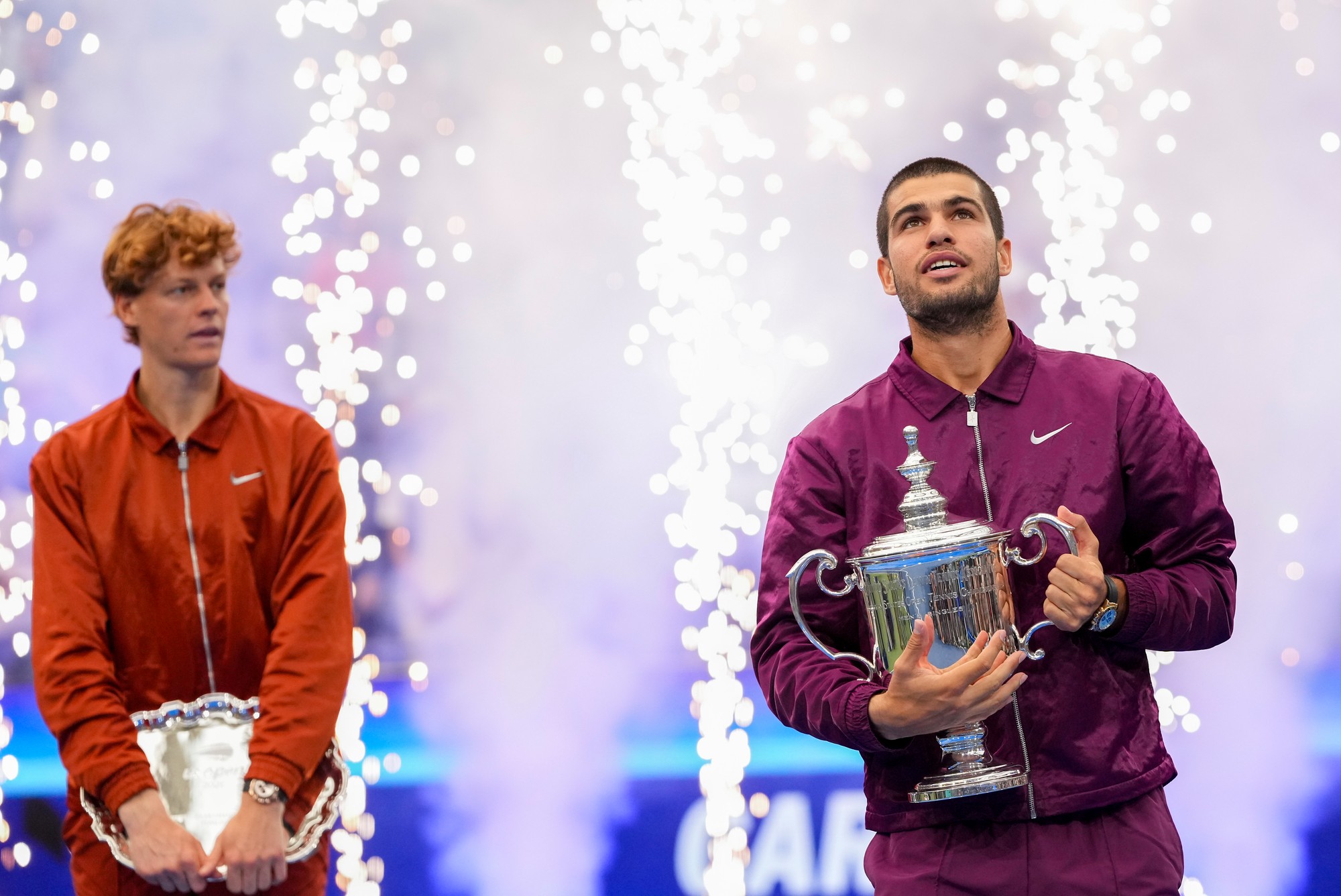 Španielsky tenista Carlos Alcaraz (vpravo) pózuje s trofejou po víťazstve nad Talianom Jannikom Sinnerom (vľavo) vo finále US Open 2025. 