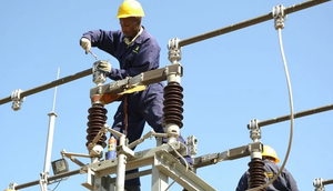 A Kenya Power employee working on a power line