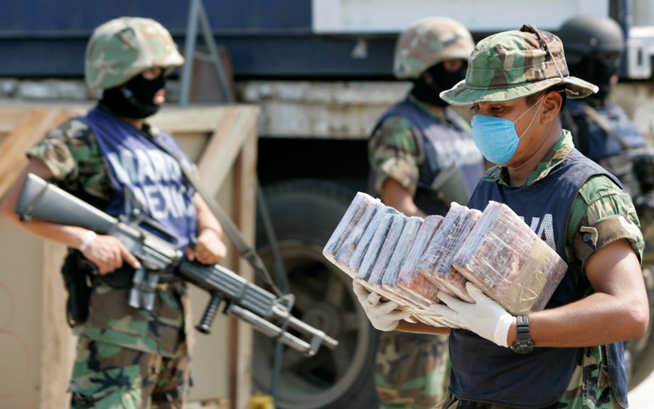 A marine carries packs of cocaine at a naval base in Manzanillo, Colima state, November 5, 2007.