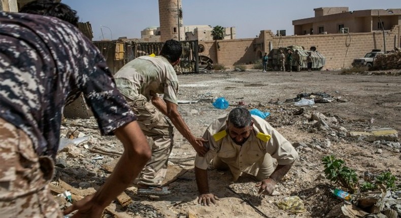 Fighters loyal to Libya's Government of National Accord help a wounded comrade after he was shot by an Islamic State group sniper on the western frontline in Sirte on October 2, 2016