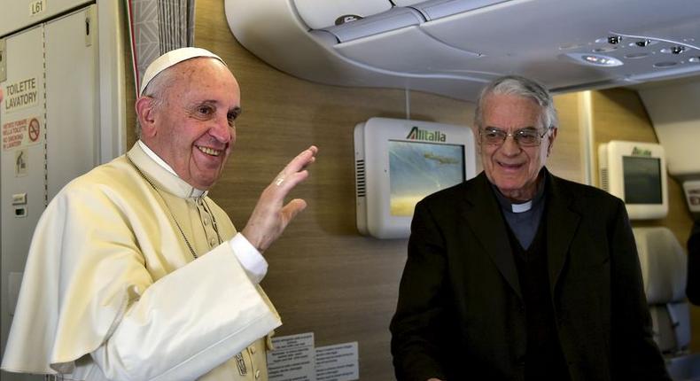 Pope Francis waves to the media aboard the papal plane while en route to Nairobi, Kenya, November 25, 2015. REUTERS/Giuseppe Cacace/pool