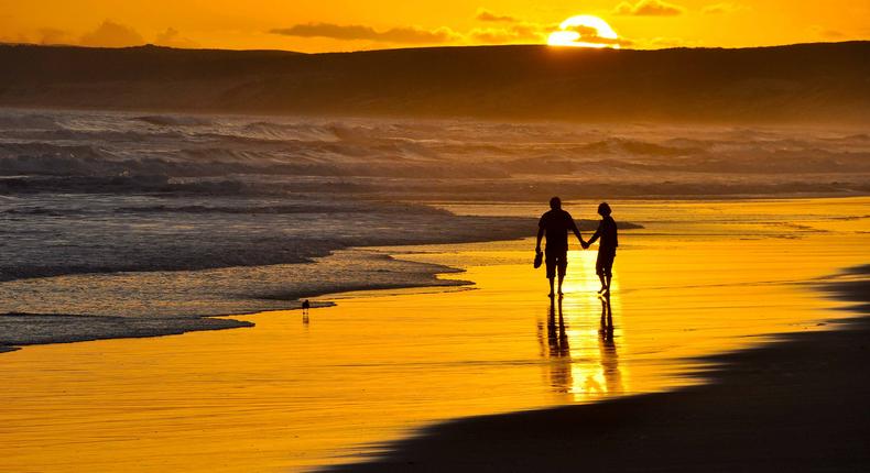 Couple taking a romantic walk on the beach at Sunset