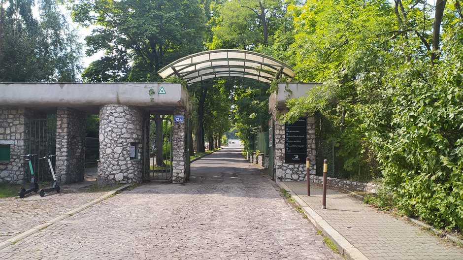 Ulica Parkowa w Krakowie. Za tą bramą można znaleźć burgery, które poleca bezfarmazonu.pl.