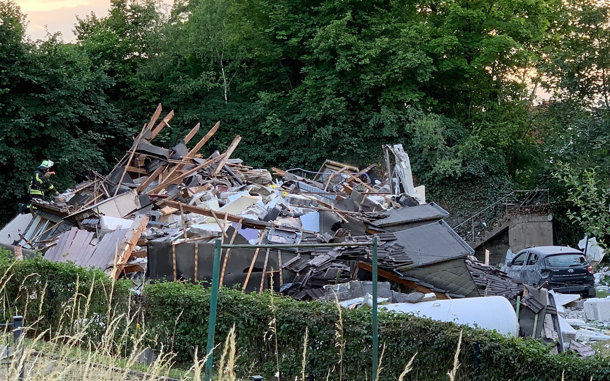Hasič skúma trosky zrúteneho obytného domu v meste Hemer na západe Nemecka.