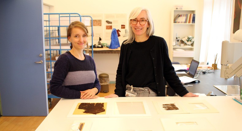 Researchers Charlotte Rimstad (left) and Ulla Mannering (right) with some of the textiles they studied.
