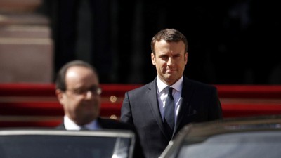 Former French President Francois Hollande leaves as President Emmanuel Macron watches after the hand