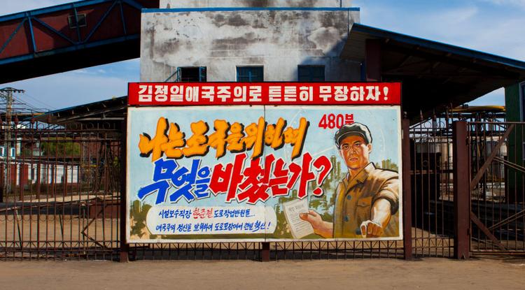 Propaganda poszter egy észak-koreai üzem falán.